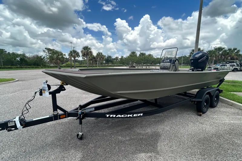 Slide: The Image of 2026 Tracker Grizzly 2072 CC boat on trailer, parked in sunny lot with cloudy sky. - 5