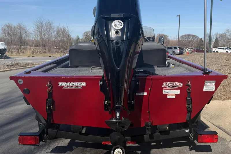 Slide: The Image of 2026 Tracker Pro 170 boat with red hull and outboard motor, parked outdoors. - 2