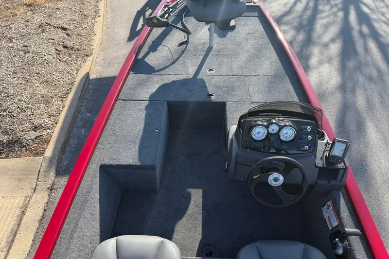 Slide: The Image of 2026 Tracker Pro 170 boat interior with steering console and seating, featuring a red trim. - 4