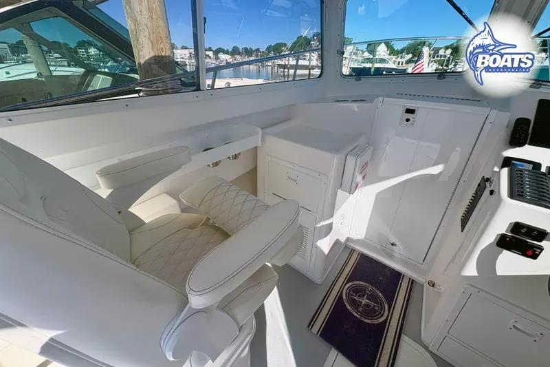 Slide: The Image of Interior of 2022 Steiger Craft 28 Miami boat, featuring white seating and control panel. - 11