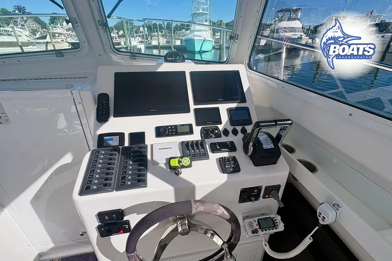 Slide: The Image of Steiger Craft 28 Miami 2022 boat helm with navigation controls and marina view. - 12