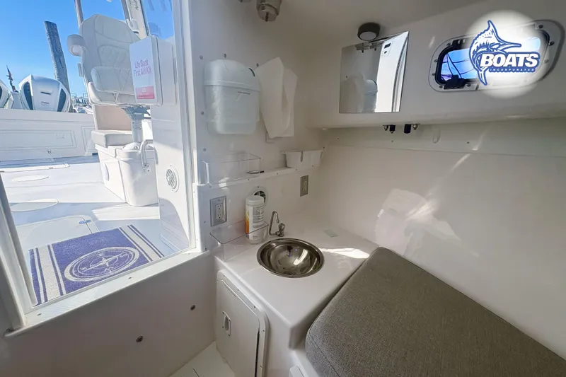 Slide: The Image of 2022 Steiger Craft 28 Miami cabin interior with sink, seating, and first aid kit. - 16