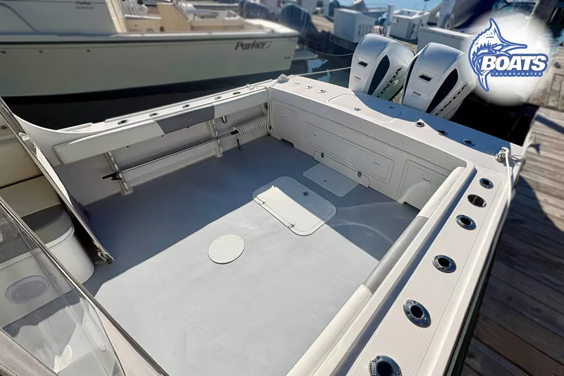 Slide: The Image of 2022 Steiger Craft 28 Miami boat deck with rod holders and twin engines at dock. - 17