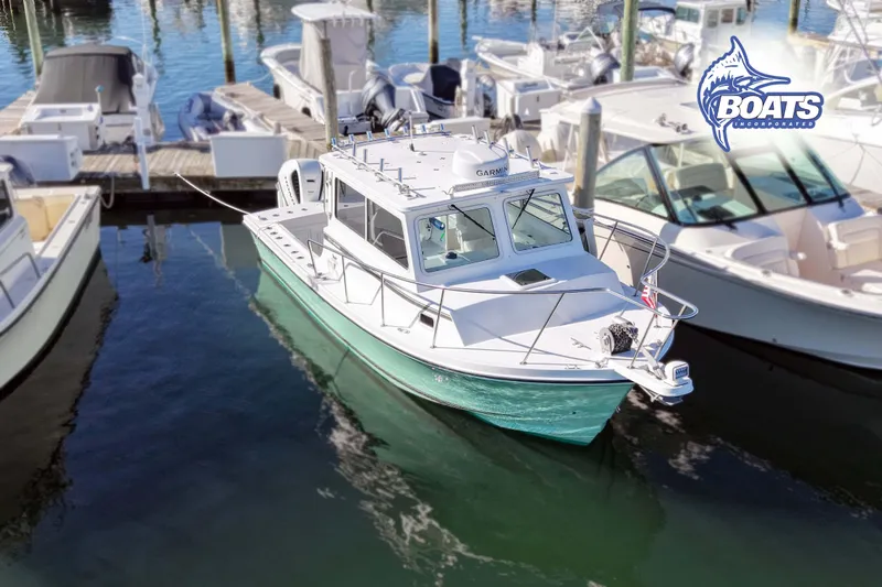 Slide: The Image of 2022 Steiger Craft 28 Miami boat docked at marina, surrounded by other vessels. - 2
