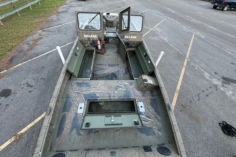 Slide: The Image of 2019 SeaArk Predator 220 AK SC boat with open deck and camouflage design in a parking lot. - 12