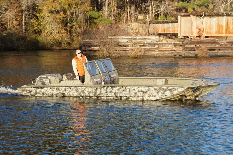 Slide: The Image of 2019 SeaArk Predator 220 AK SC boat cruising on a calm river. - 4