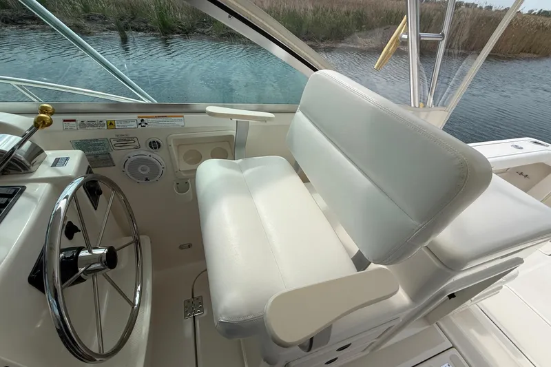 Slide: The Image of Helm of 2001 Pursuit 3400 Express boat with white seating and steering wheel. - 15