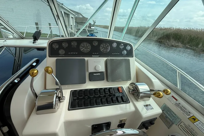 Slide: The Image of Control panel of a 2001 Pursuit 3400 Express boat, featuring gauges and throttle levers. - 16