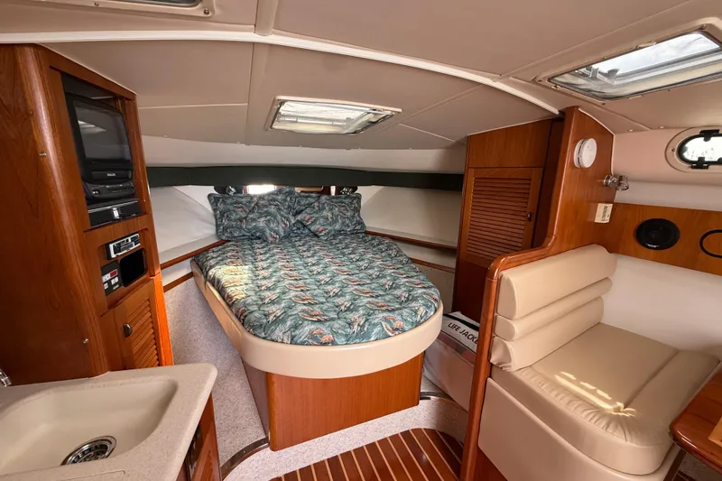 Slide: The Image of Interior of 2001 Pursuit 3400 Express boat with cozy bed and wooden cabinetry. - 23