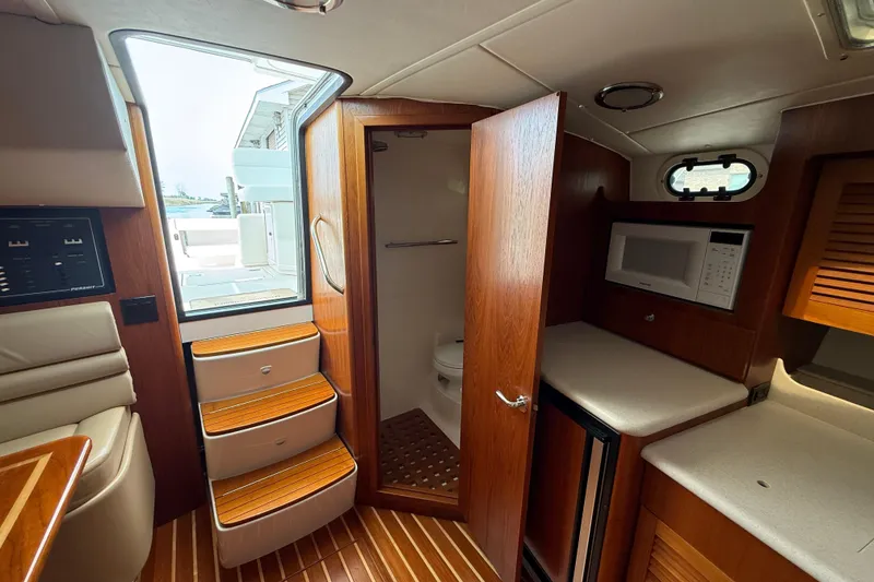 Slide: The Image of Interior of 2001 Pursuit 3400 Express boat with kitchenette and bathroom. - 26