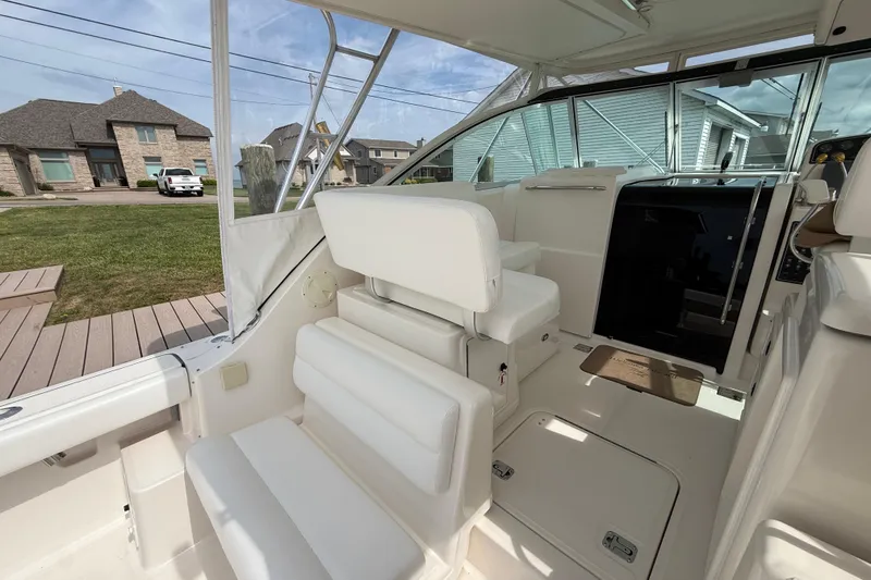 Slide: The Image of Captain's chair on 2001 Pursuit 3400 Express boat, covered, near water. - 31