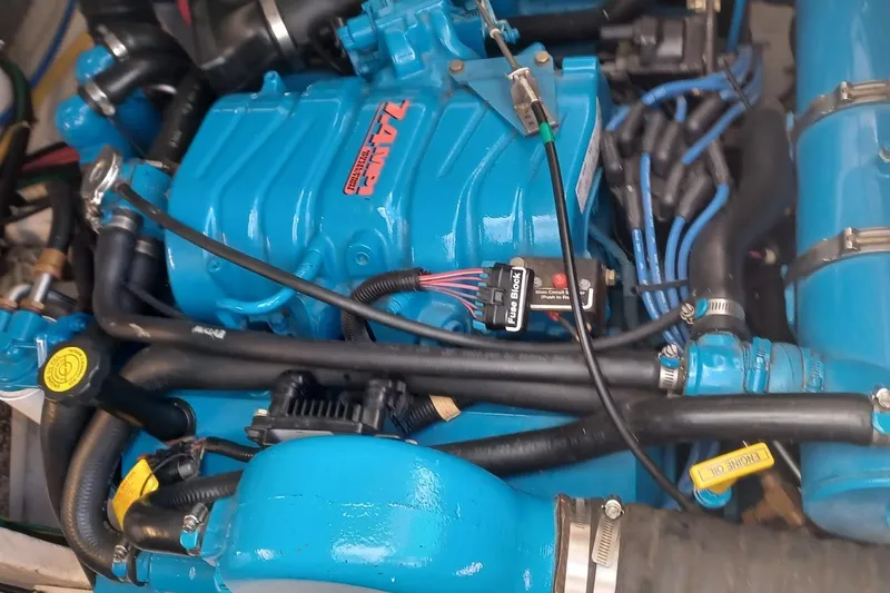 Slide: The Image of Engine of a 2001 Pursuit 3400 Express boat, featuring blue components and wiring. - 33