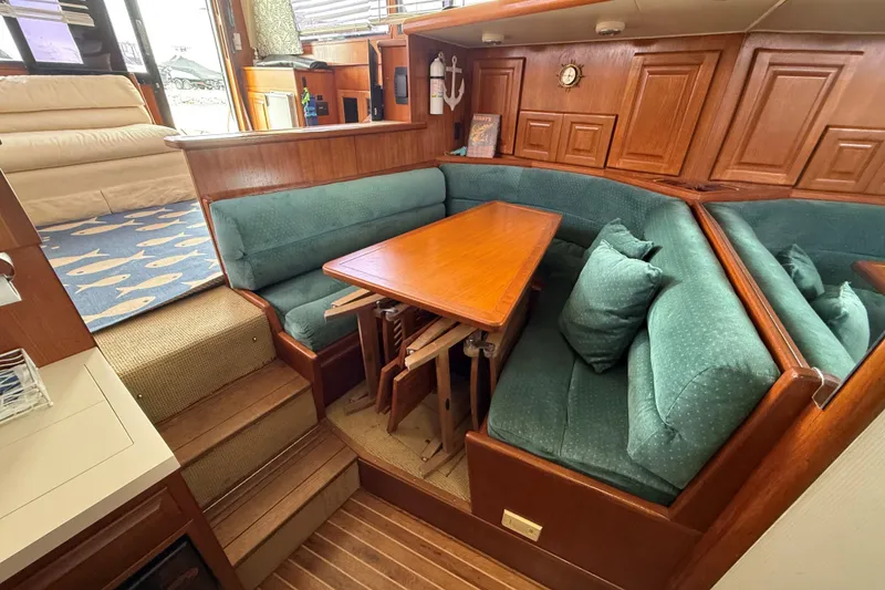 Slide: The Image of 1989 Viking 41 Convertible yacht interior with wooden dining area and teal cushions. - 14