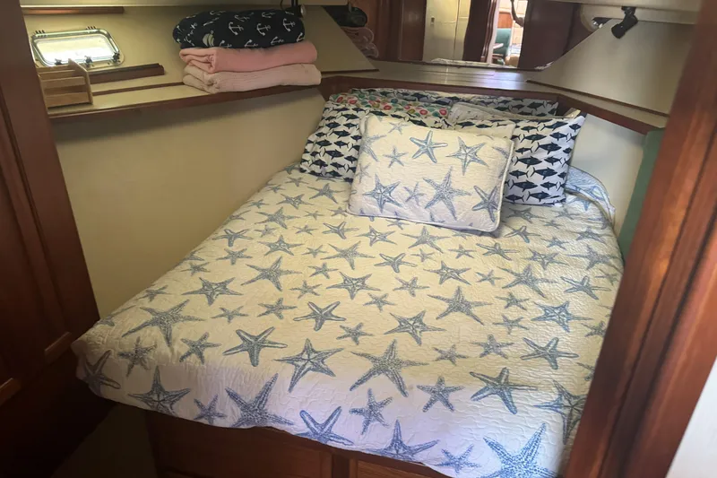 Slide: The Image of Cozy cabin bedroom in 1989 Viking 41 Convertible with starfish-themed bedding. - 17