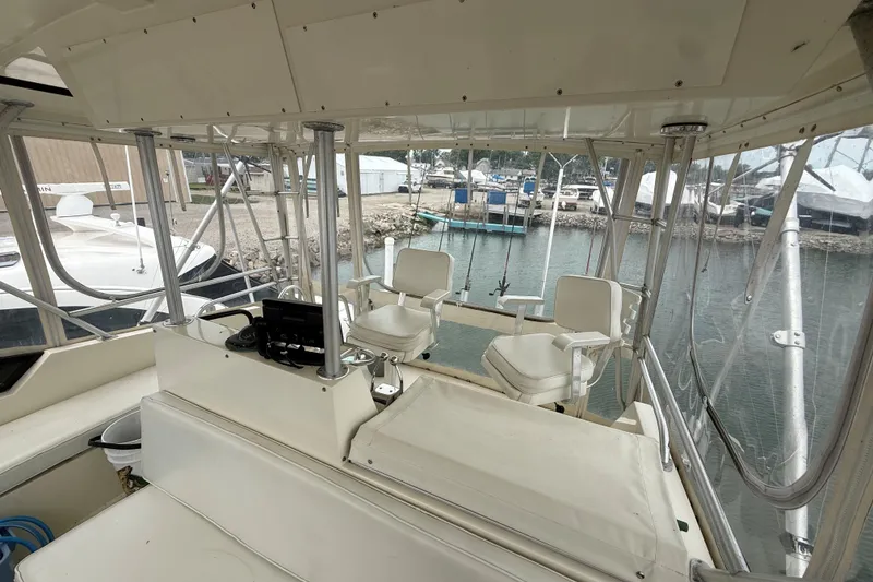Slide: The Image of 1989 Viking 41 Convertible boat interior with helm and seating, docked at marina. - 9