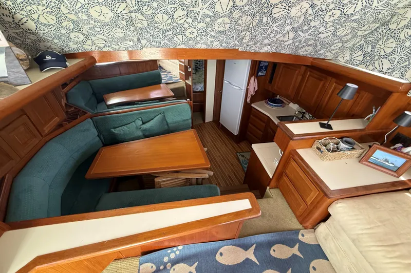 Slide: The Image of 1989 Viking 41 Convertible yacht interior with cozy seating, wooden cabinetry, and nautical decor. - 13