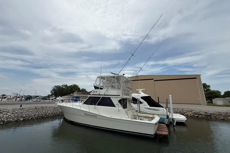 Slide: The Image of 1989 Viking 41 Convertible yacht docked at marina under cloudy sky. - 3