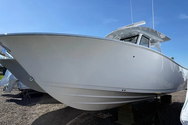 The Image of 2026 Sportsman Open 322 Center Console boat on display under clear blue sky. - 0