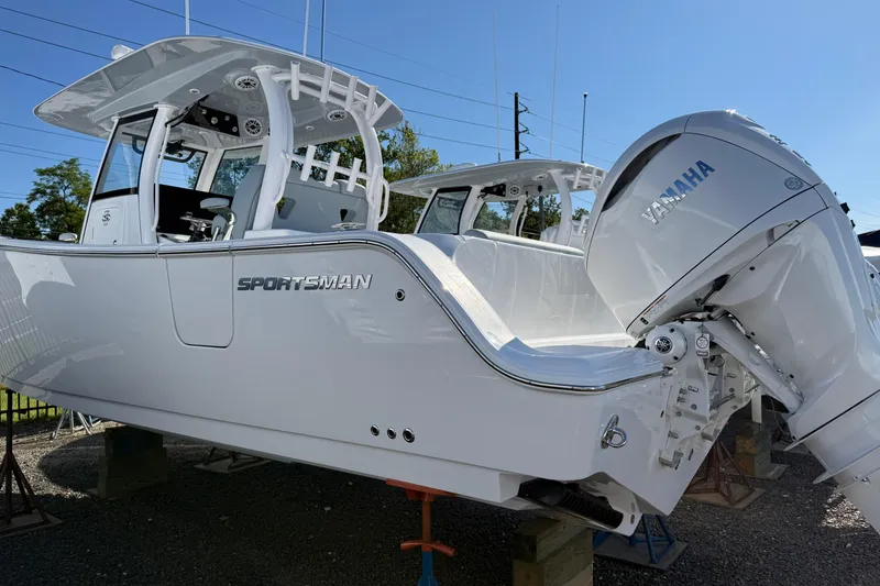 Slide: The Image of 2026 Sportsman Open 322 Center Console boat with Yamaha engine, displayed outdoors. - 1