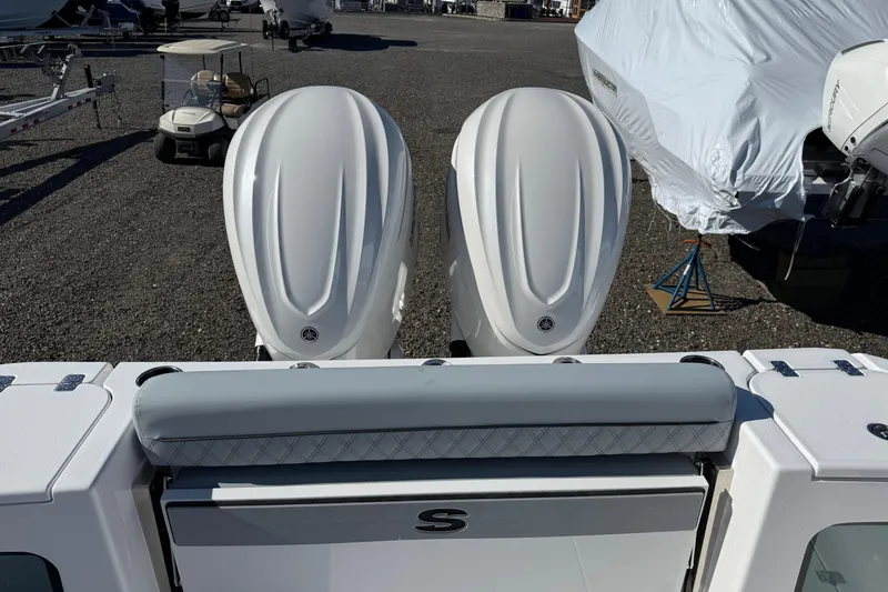 Slide: The Image of 2026 Sportsman Open 322 Center Console with dual outboard engines in a boatyard. - 15