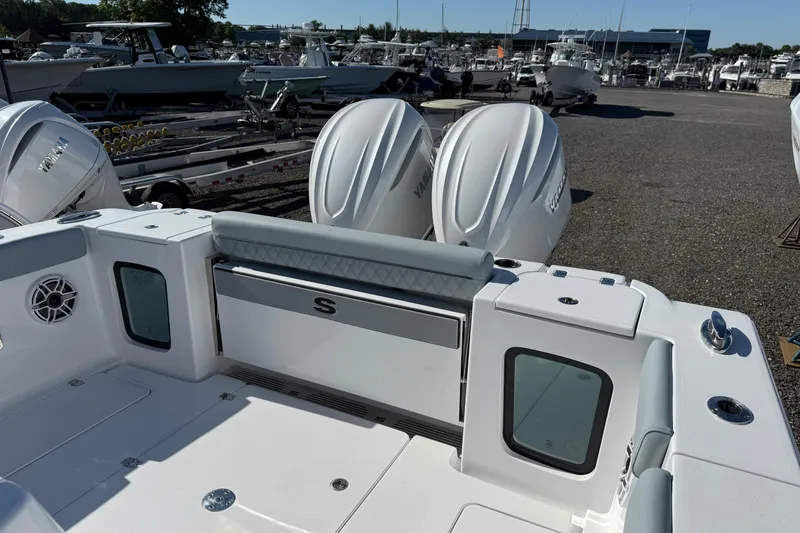 Slide: The Image of 2026 Sportsman Open 322 Center Console boat with dual engines at a marina. - 16