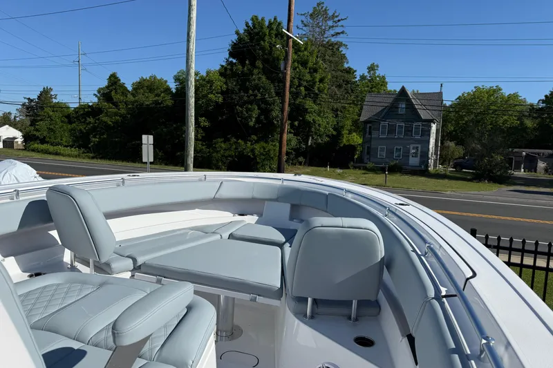 Slide: The Image of 2026 Sportsman Open 322 Center Console boat with sleek seating, parked near a road. - 6