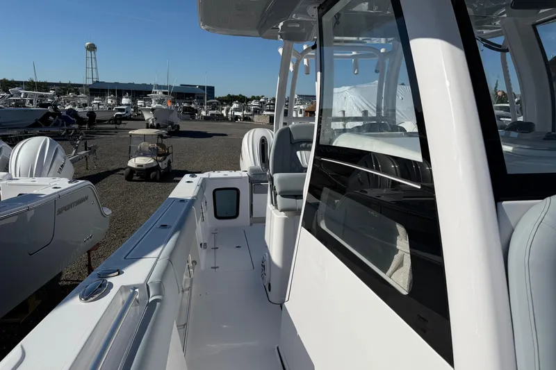 Slide: The Image of 2026 Sportsman Open 322 Center Console boat at marina, showcasing sleek design and spacious deck. - 8