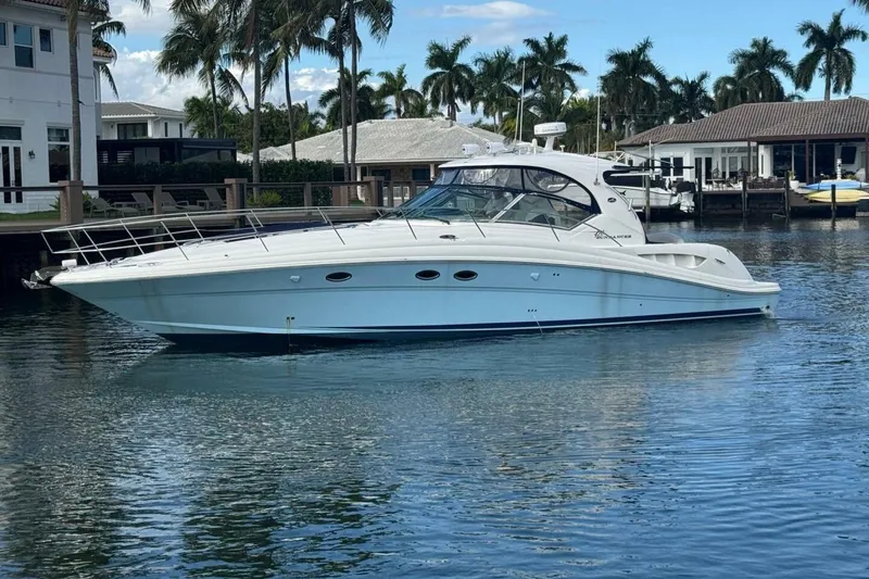 Slide: The Image of 2005 Sea Ray 420 Sundancer yacht docked in a scenic waterfront setting with palm trees. - 0