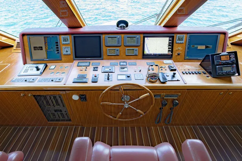 Slide: The Image of 2009 Hargrave Enclosed Bridge yacht helm with navigation controls and wooden steering wheel. - 26