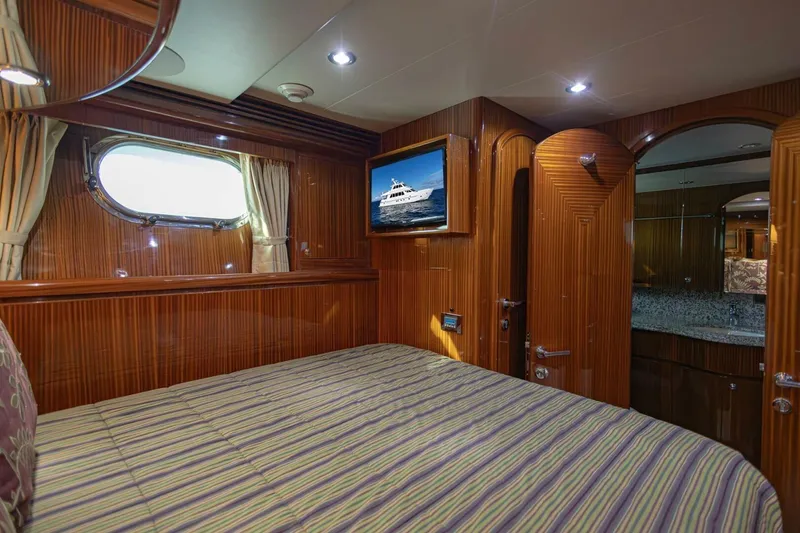 Slide: The Image of Luxurious 2009 Hargrave Enclosed Bridge yacht bedroom with wood paneling and porthole window. - 46