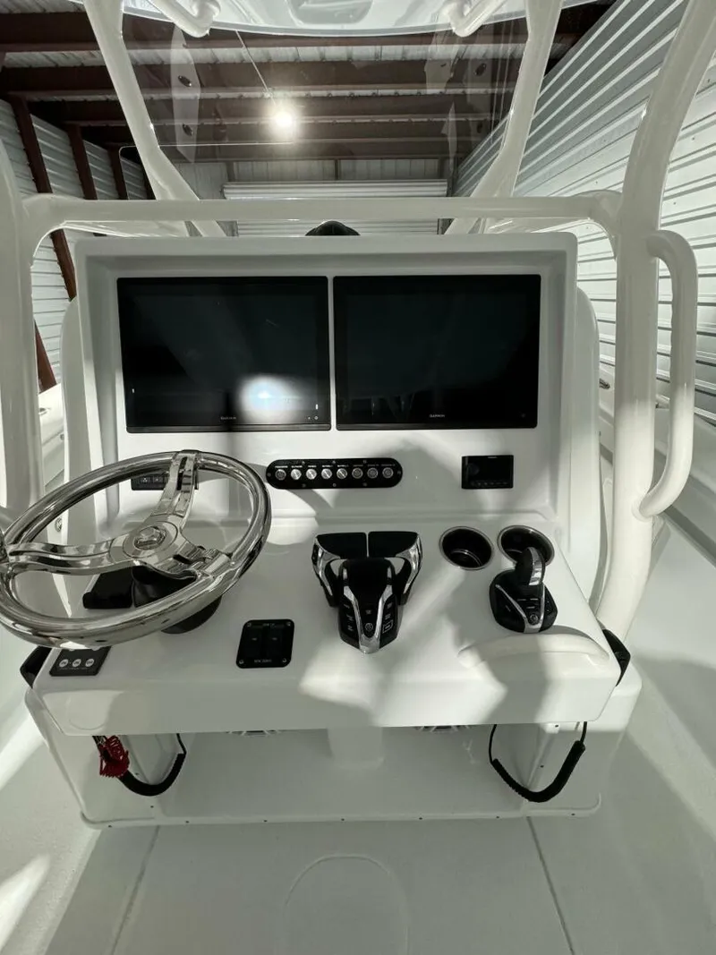 Slide: The Image of 2024 Yellowfin 36 boat console with dual screens and steering wheel in a storage facility. - 9