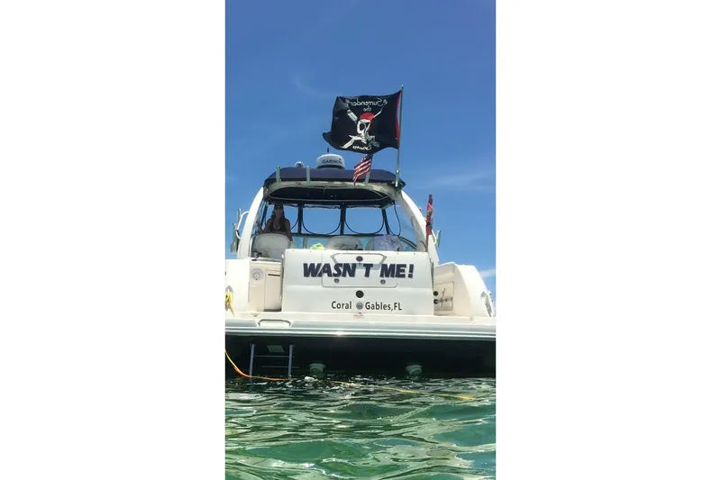 Slide: The Image of 2006 Sea Ray 340 Sundancer boat with pirate flag, "WASN'T ME!" text, Coral Gables, FL. - 1