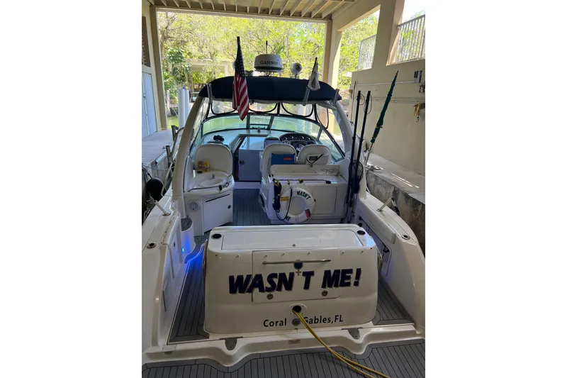 Slide: The Image of 2006 Sea Ray 340 Sundancer boat docked, featuring fishing rods and American flag. - 2