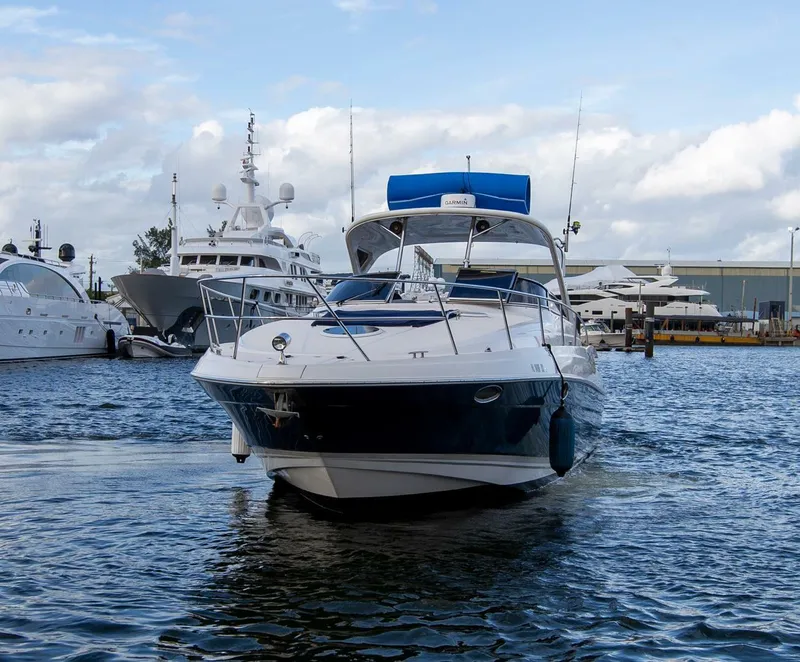 Slide: The Image of 2008 Regal 38 yacht docked in marina, surrounded by other luxury boats. - 2