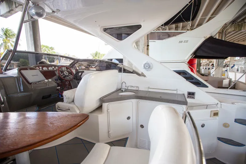 Slide: The Image of 2008 Regal 38 yacht interior with helm, seating, and kitchenette under a canopy. - 22