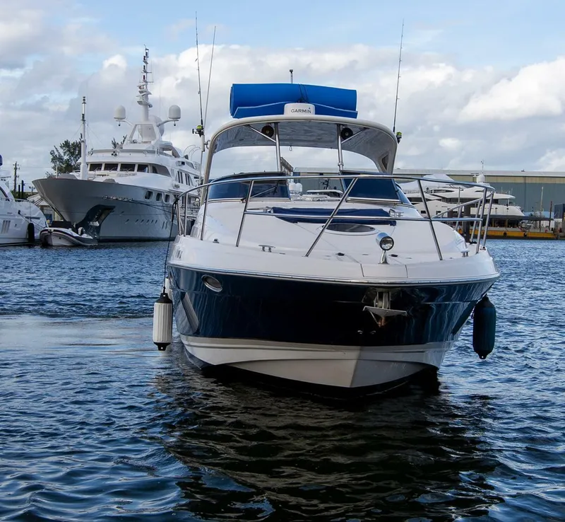 Slide: The Image of 2008 Regal 38 boat docked in marina, surrounded by other yachts under cloudy sky. - 4