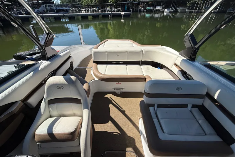 Slide: The Image of 2018 Cobalt CS22 boat interior with plush seating, docked on calm water. - 8