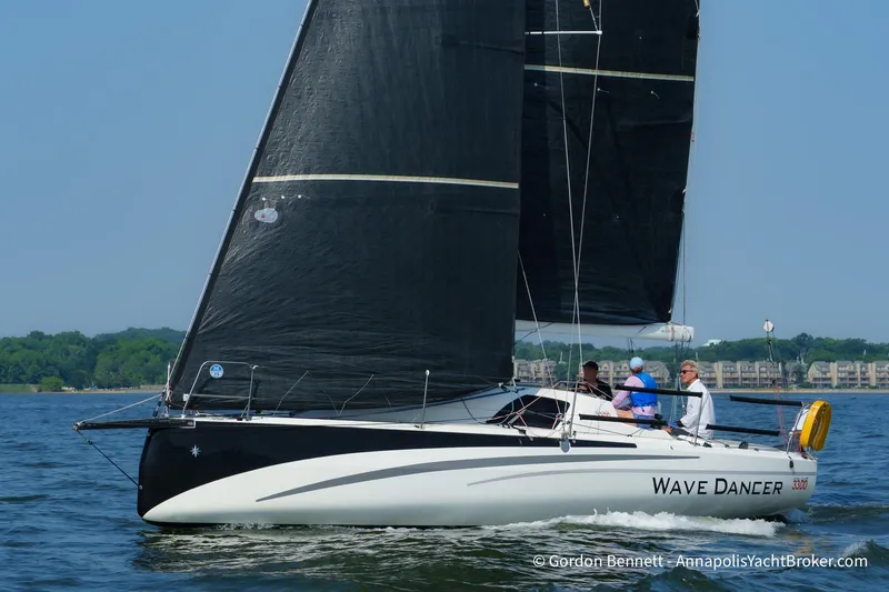 Slide: The Image of 2020 Jeanneau Sun Fast 3300 sailboat "Wave Dancer" on water, black sails, clear sky. - 5
