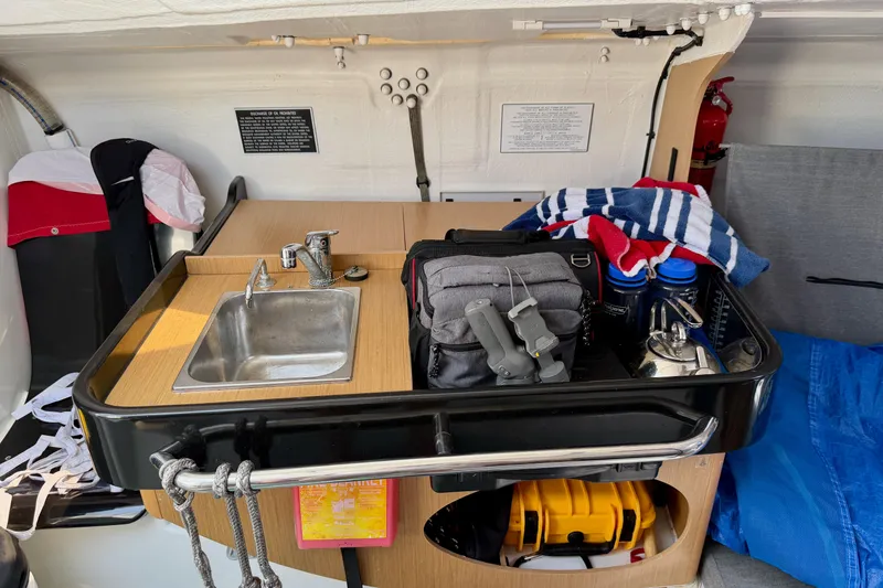 Slide: The Image of Interior of 2020 Jeanneau Sun Fast 3300 sailboat with compact kitchen and storage area. - 45