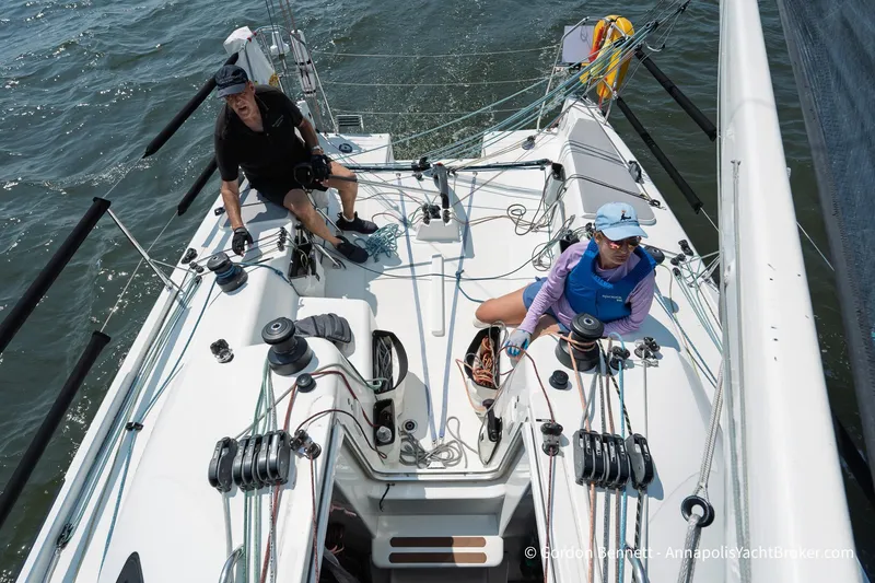 Slide: The Image of Two sailors navigating a 2020 Jeanneau Sun Fast 3300 on open water. - 28