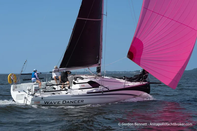 The Image of 2020 Jeanneau Sun Fast 3300 sailboat "Wave Dancer" with pink spinnaker on open water. - 0