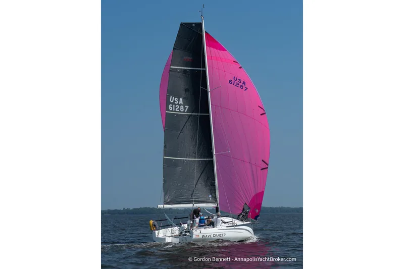 Slide: The Image of 2020 Jeanneau Sun Fast 3300 sailboat with vibrant pink and black sails on open water. - 10