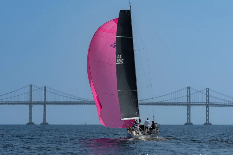 Slide: The Image of 2020 Jeanneau Sun Fast 3300 sailing with pink spinnaker near a large bridge. - 12