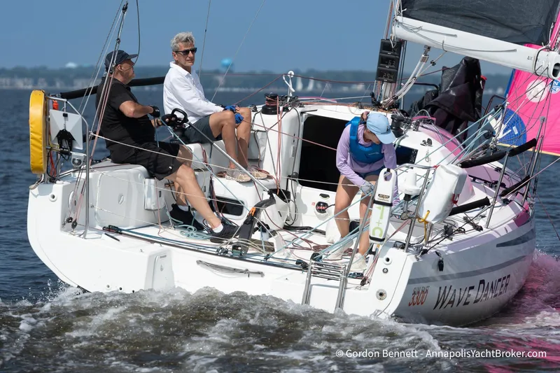 Slide: The Image of 2020 Jeanneau Sun Fast 3300 sailboat "Wave Dancer" with crew navigating on open water. - 3