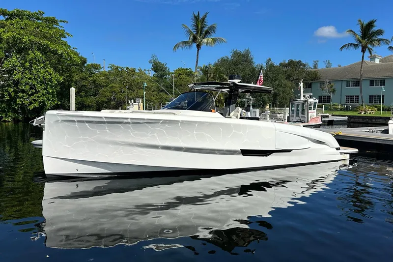 The Image of 2025 Solaris Power 44 Open yacht docked, reflecting on calm water, surrounded by lush greenery. - 1