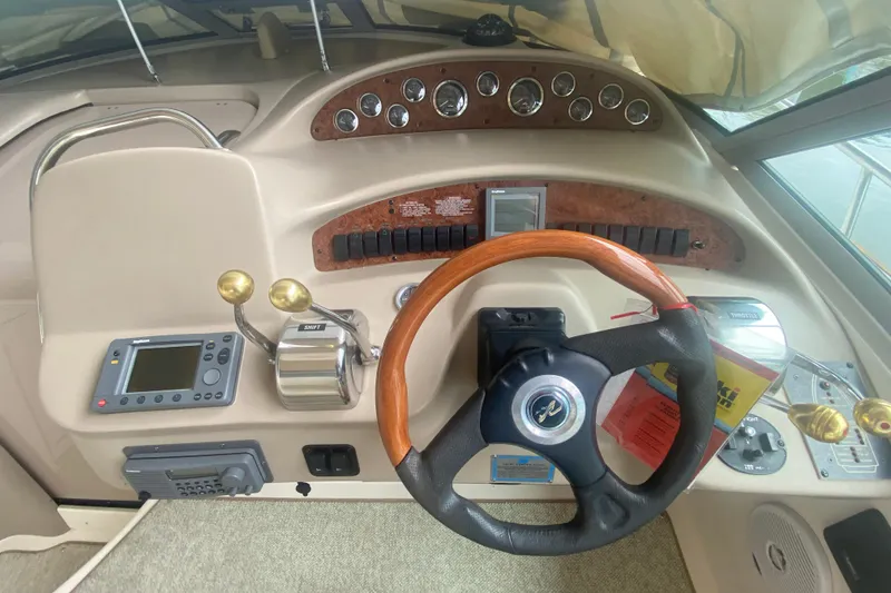 Slide: The Image of Helm of 2001 Sea Ray 340 Sundancer with wood steering wheel and control panel. - 13