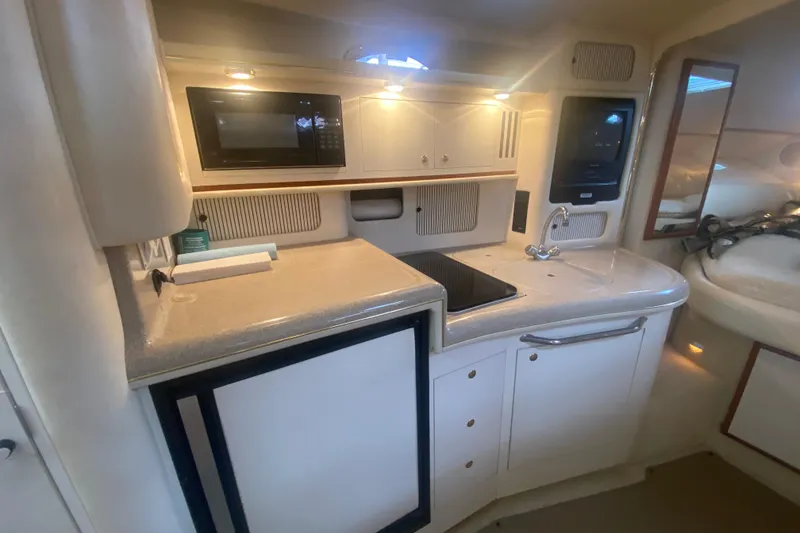Slide: The Image of 2001 Sea Ray 340 Sundancer yacht kitchen with microwave, sink, and storage cabinets. - 17
