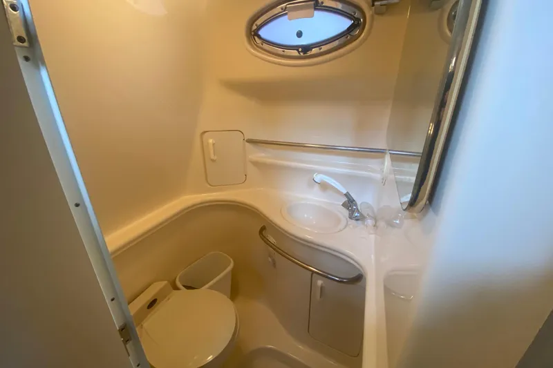 Slide: The Image of Compact bathroom in 2001 Sea Ray 340 Sundancer yacht with sink, toilet, and porthole window. - 29