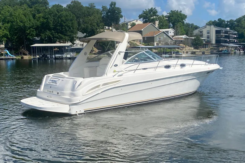 Slide: The Image of 2001 Sea Ray 340 Sundancer boat cruising on a serene lake with lush greenery. - 5