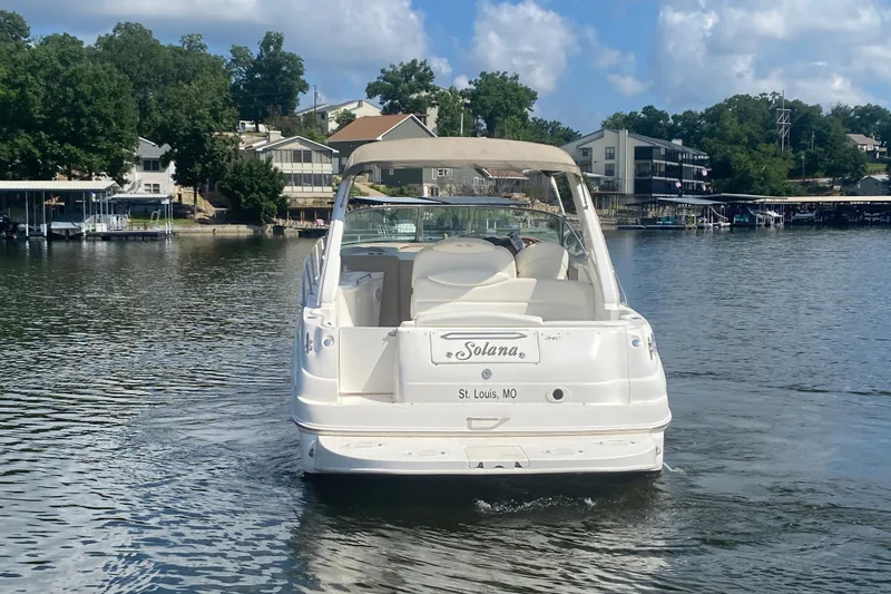 Slide: The Image of 2001 Sea Ray 340 Sundancer boat on a lake, surrounded by trees and houses. - 3